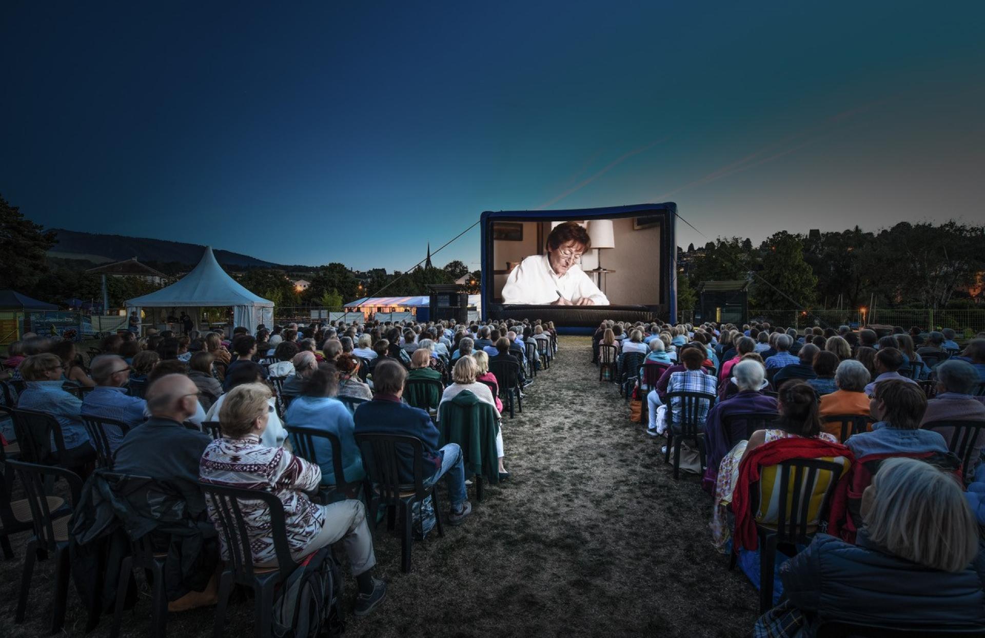 Menschen geniessen einen Film unter freiem Himmel im Openair Kino